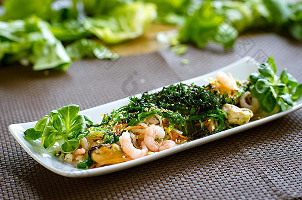 健康的日本沙拉海鲜海藻芝麻种子白色板
