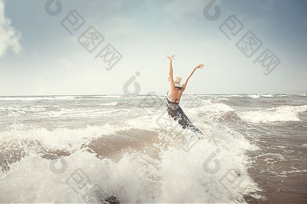 快乐的黑发女士在海里玩海浪