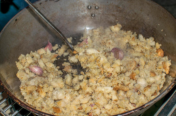 烹饪米加或面包屑，一种典型的西班牙食物。2019年，西班牙穆尔西亚，用煎锅准备面包屑。