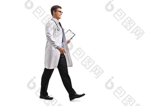 在白色背景上，一<strong>名医</strong>生用剪贴板独立行走的全长侧面照片