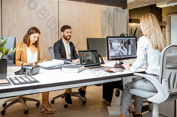 创意办公室的员工坐在建筑公司的现代办公室里，在电脑上进行室内设计。三维建模概念与数字室内设计