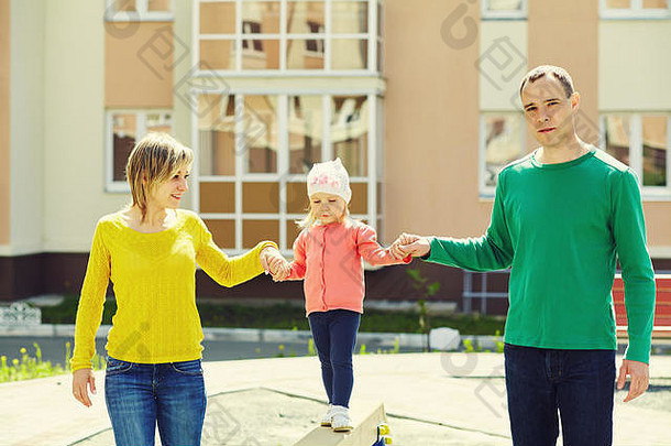 户外快乐家庭。年轻的父母带着孩子在夏天散步。妈妈、爸爸和孩子