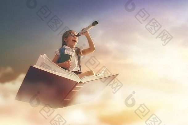回到学校！快乐可爱勤劳的孩子在夕阳天空的背景下在书上飞翔。教育和阅读的概念。发展
