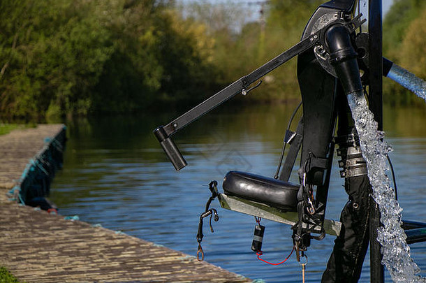 寻求刺激者和水上运动爱好者的喷气式背包套装位于湖边，供主人系上安全带，在湖面上享受水上运动。