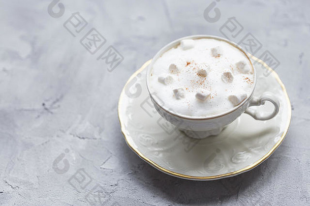 咖啡饮料、棉花糖和肉桂装在灰色背景的复古白色杯中