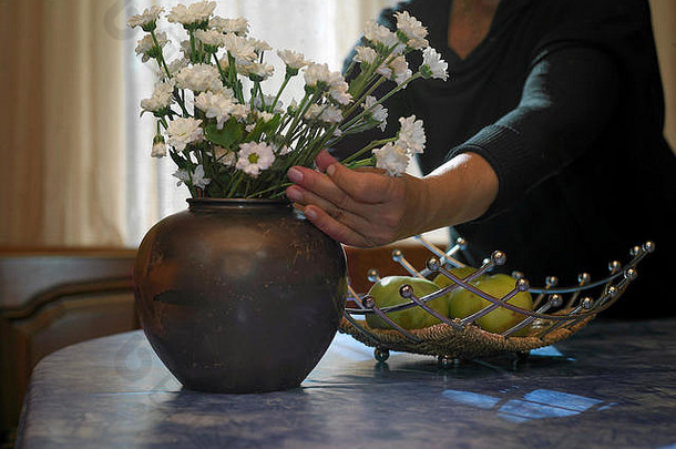 女人安排花束花瓶室内裁剪图像