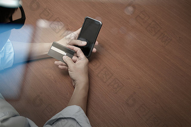 使用手机和持有的手的俯视图，以社交媒体图作为在线购物概念