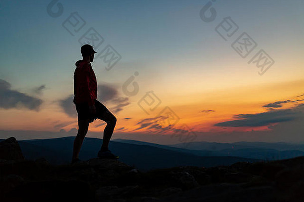 男人。庆祝日落山前鼓舞人心的视图小道跑步者徒步旅行者登山者达到了山峰享受鼓舞人心的景观