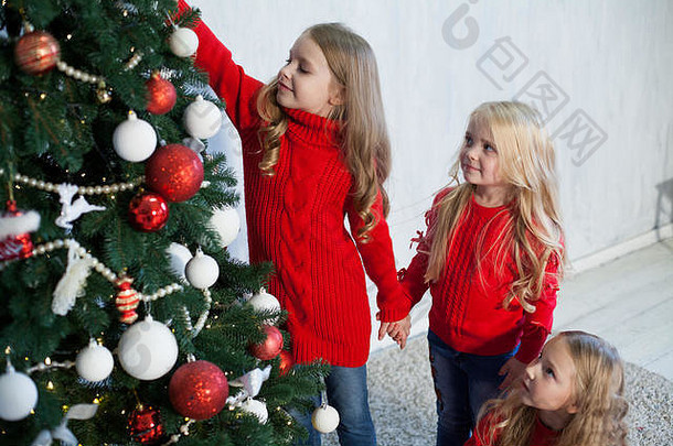 三个小女孩在圣诞礼物和新年假期穿红衣服