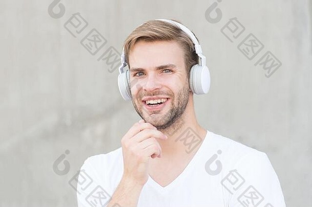 耳机合适的头大小快乐的家伙穿耳机灰色背景英俊的男人。微笑耳朵立体声耳机现代设计耳机技术生活生活大声