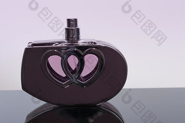 黑色亚克力薄片上的心形香水瓶。