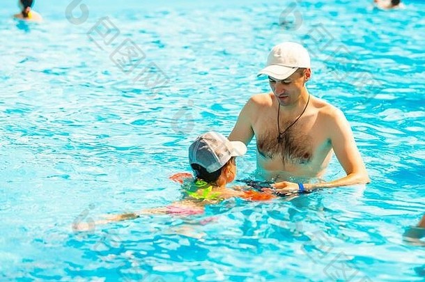 父亲和女儿在游泳池里玩