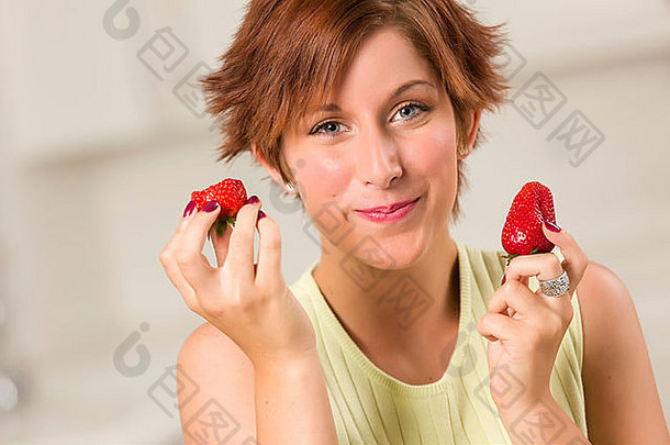 <strong>漂亮</strong>的红色的头发的女人吃草莓<strong>厨房</strong>