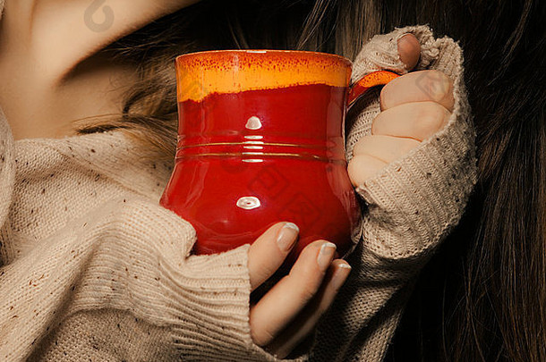 热饮料特写镜头红色的杯杯子喝茶咖啡女手女人温暖的毛衣气候变暖