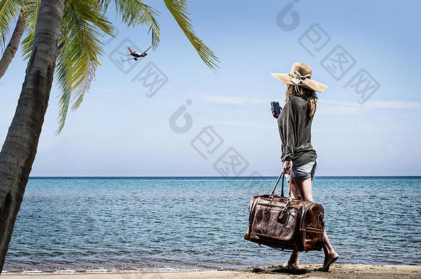 海滩上的女士，带着复古皮包-旅行理念
