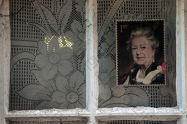 在一个热心的保皇党人的小屋的窗户里，玻璃上贴着女王的照片