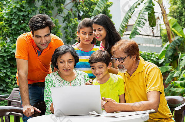 快乐的大家庭祖父母父母父母和孩子一起在家花园里看笔记本电脑屏幕视频聊天
