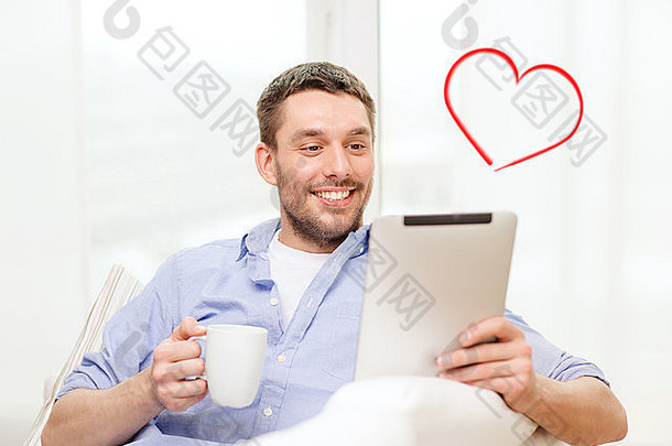 微笑的男人在家里使用平板电脑