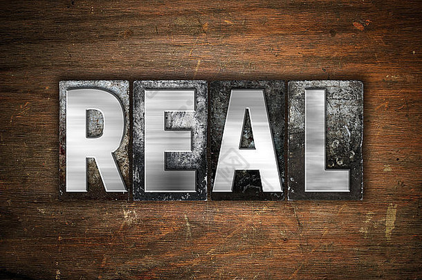 “真实”一词是在古老的木质背景上用复古金属活版印刷的。