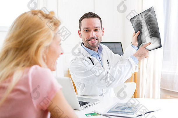 一位年轻迷人的医生与患者一起分析X光片的画面