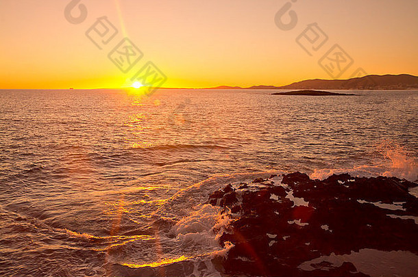 黄色的夕阳，远处的渡口和波浪。马洛卡，巴利阿里群岛，西班牙
