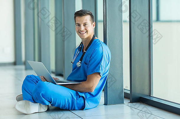 坐在医院地板上使用笔记本电脑的医务人员