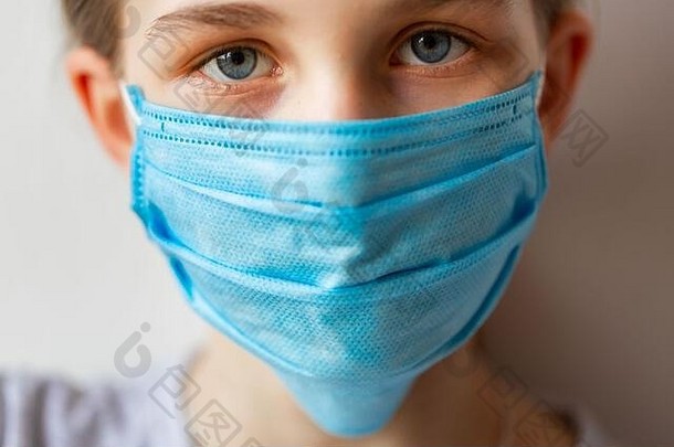 戴着医学面具的小女孩既伤心又害怕。冠状病毒防护，戴口罩概念
