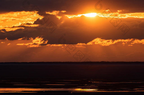 落日余晖把天空涂成了黄色和橙色。海上美丽的日落。俄罗斯、西伯利亚、新西伯利亚地区。