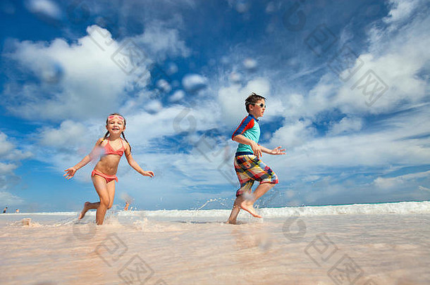 快乐的孩子们在海滩上奔跑和跳跃