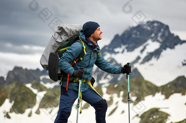 徒步旅行者站在山顶的悬崖上。男人有背包和<strong>登山杖</strong>。<strong>登山</strong>。拷贝空间