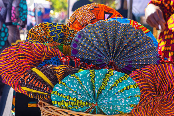 充满活力的彩色的球迷使西非洲织物出售当地的市场