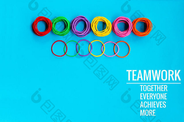 团队合作理念。蓝色背景上的一组彩色橡皮筋，上面写着“团队合作”字样，大家在一起，成就非凡