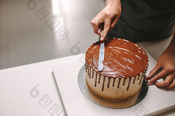 专业糖果店装修美味的蛋糕巧克力结霜厨房计数器糕点老板准备巧克力蛋糕