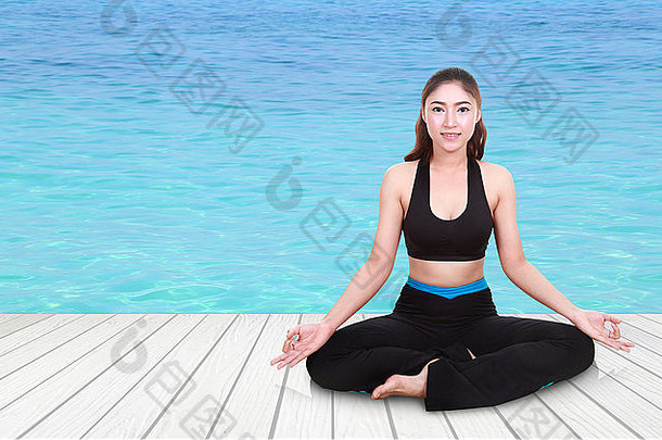 年轻的女人瑜伽锻炼木地板上海背景
