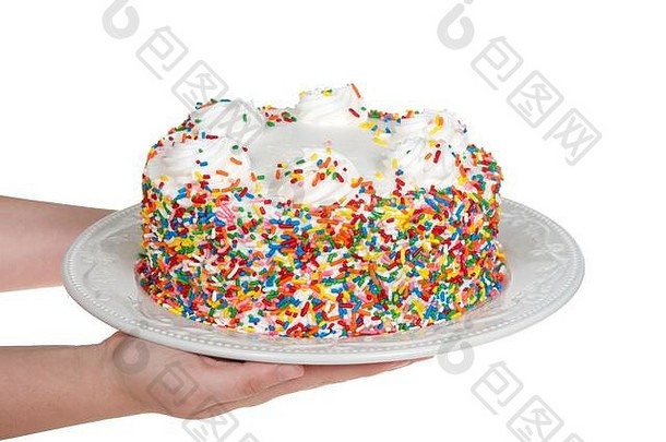 年轻的高加索人手持有香草蛋糕生奶油结霜覆盖糖果洒瓷板孤立的白色节日