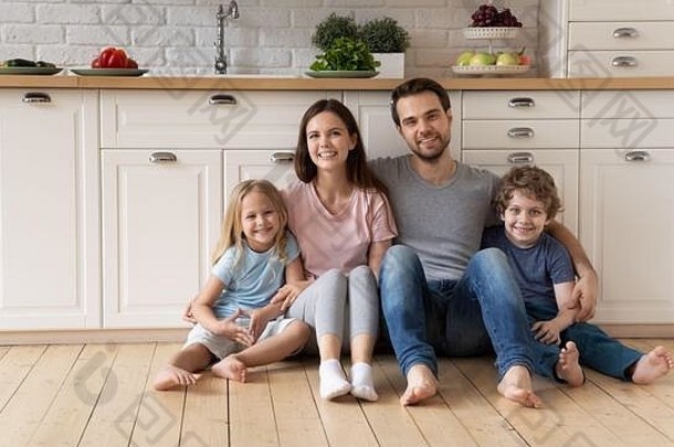 厨房地板上的快乐家庭放松画像