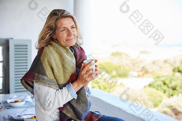 宁静的女人在院子里喝咖啡