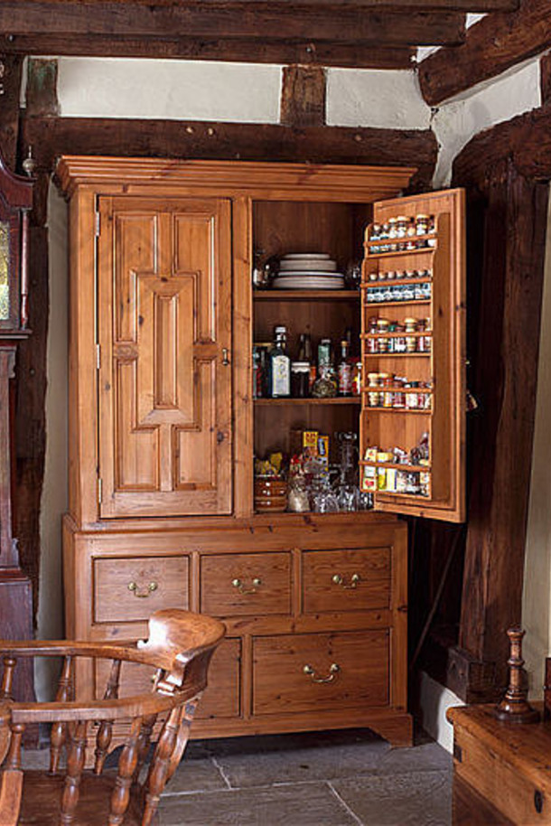 农舍厨房，带长壳钟，旁边有大型雕刻古董储藏柜，柜门敞开