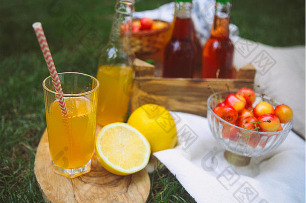 复古的玻璃柠檬水柠檬木桌子上瓶柠檬水樱桃梨柠檬花园picn