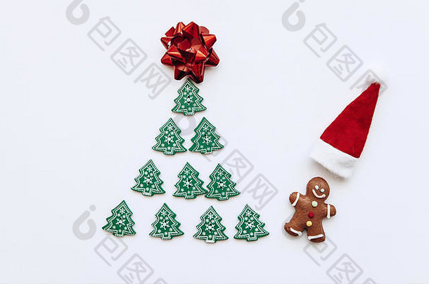 一棵来自其他小木树的圣诞树和附近一个姜黄色的小个子<strong>男人</strong>，旁边是一顶红色的圣诞老人帽。简约<strong>风格</strong>的圣诞<strong>节</strong>或新年概念。