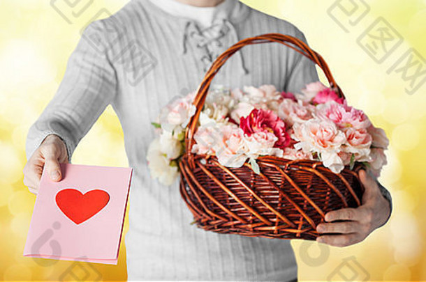 男人拿着装满鲜花和明信片的篮子
