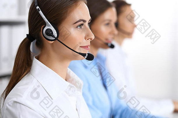 呼叫中心。一组正在工作的操作员。关注戴耳机的美丽女商人