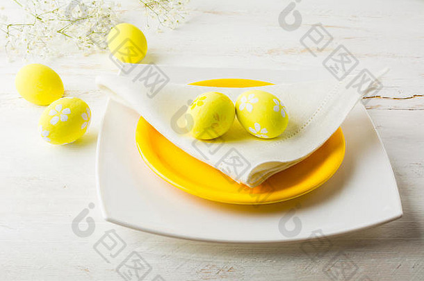黄色的复活节表格的地方设置板餐巾黄色的装饰复活节鸡蛋白色木背景