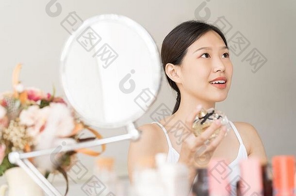 亚洲女孩香水年轻的女人应用香水手腕闻