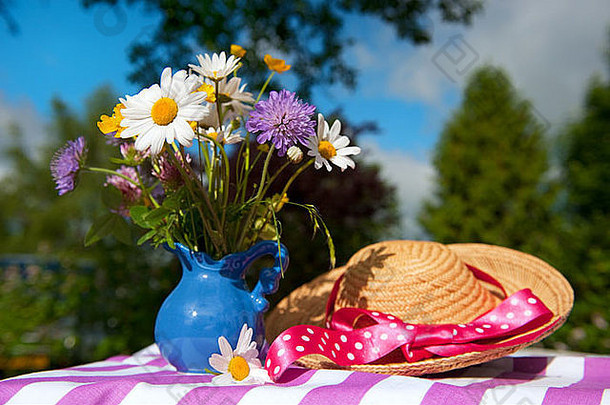 花瓶里的野花和花园里的夏帽