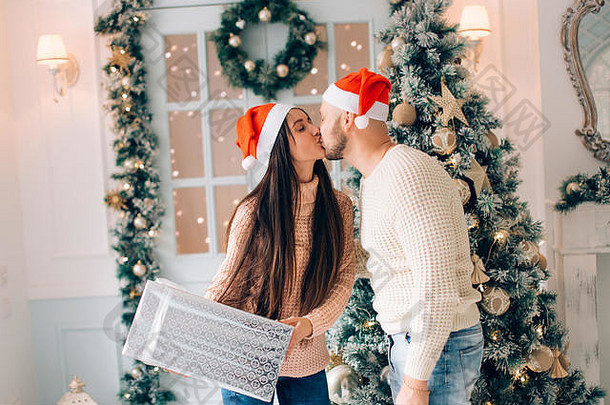 一个男人用圣诞礼物给他的女朋友惊喜的剪影。