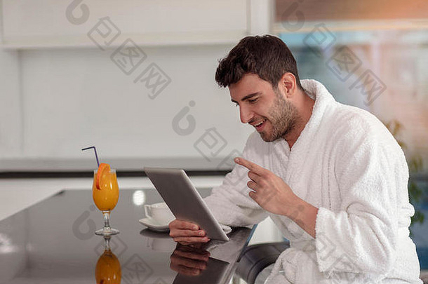 年轻的自由职业者浴袍工作首页平板电脑电脑