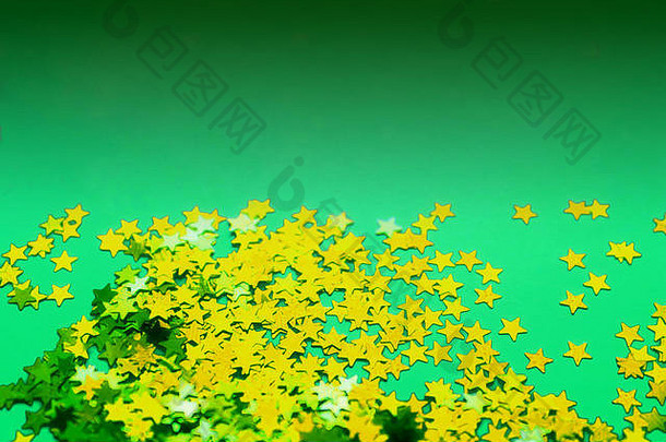 绿纸背景，<strong>金色</strong>闪烁的星星。平铺。假日概念。新年时间。调<strong>光效</strong>应