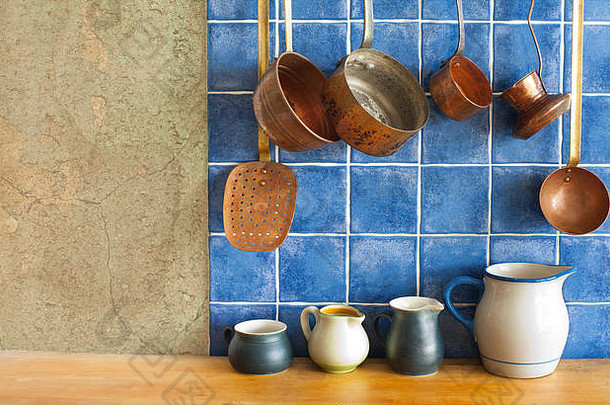 厨房内部。悬挂复古设计铜厨具套装。锅，炖锅，咖啡壶，勺子，撇渣器。