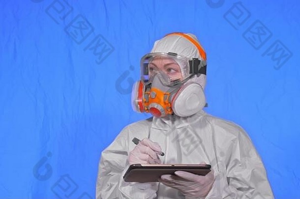 戴口罩的科学家病毒学家用手写笔在平板电脑上书写。戴医用防护面具的妇女。色度键蓝色。